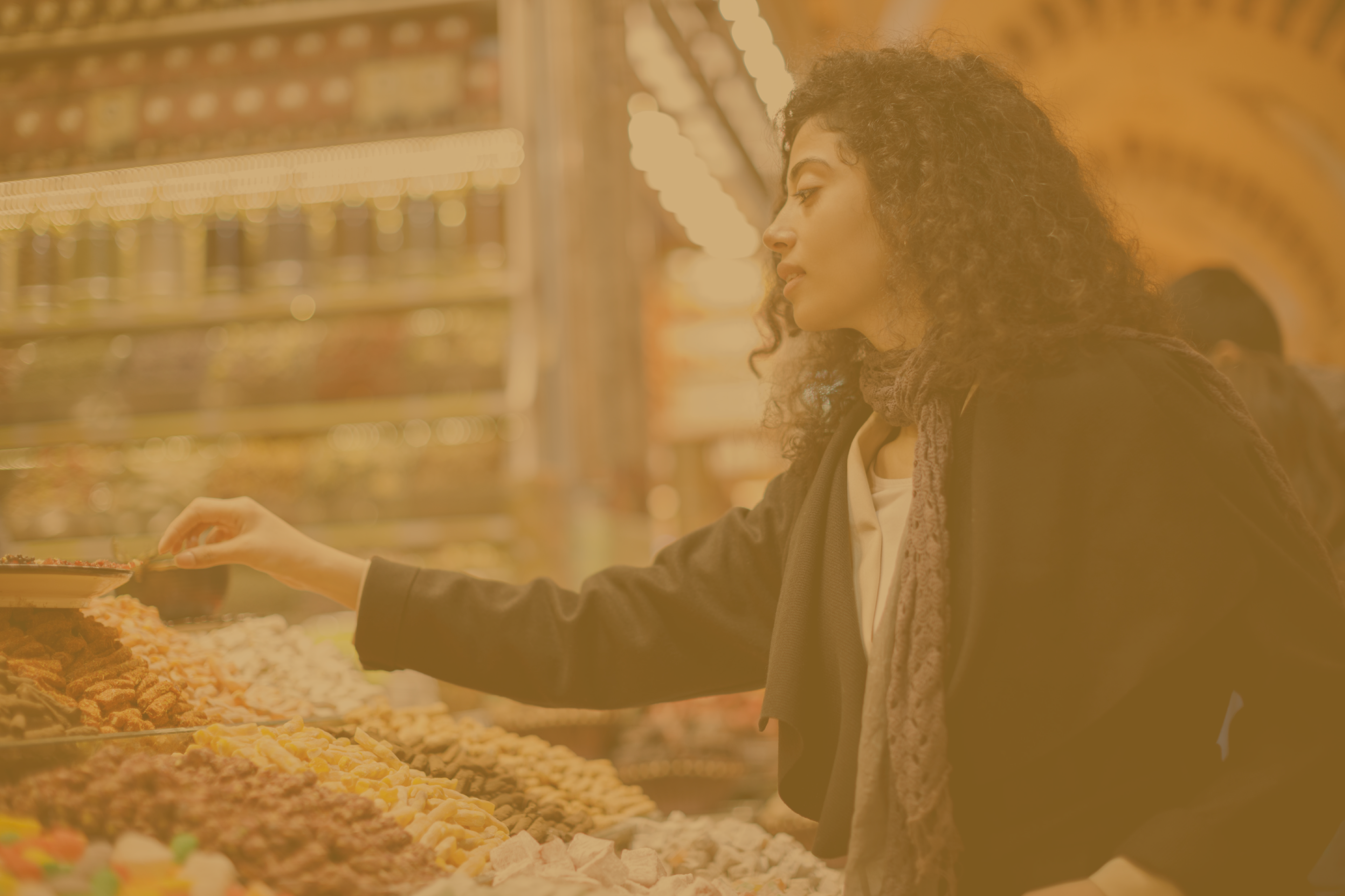 a banner image depicting a customer in a dryfruit store where she is trying to decide which item to buy 
