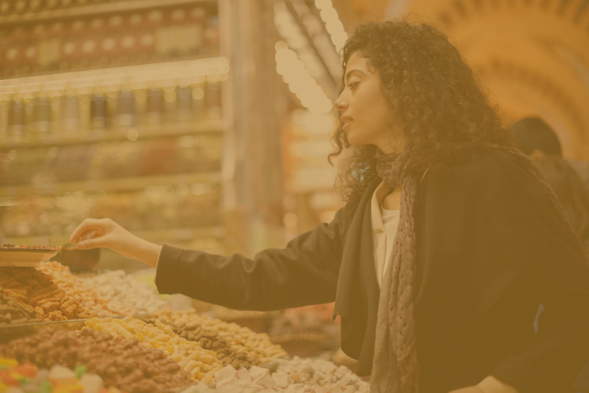 a banner image depicting a customer in a dryfruit store where she is trying to decide which item to buy 